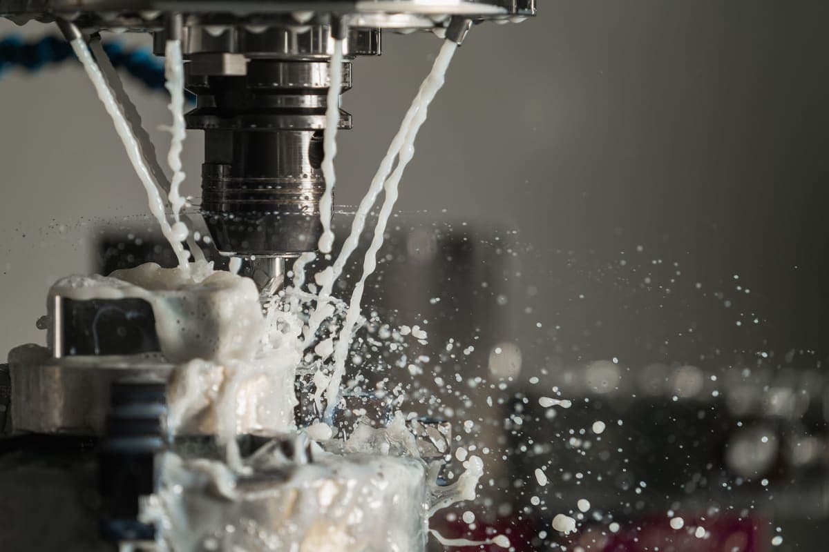 Coolant washing over a cutting tool on a CNC machine mid-cut.